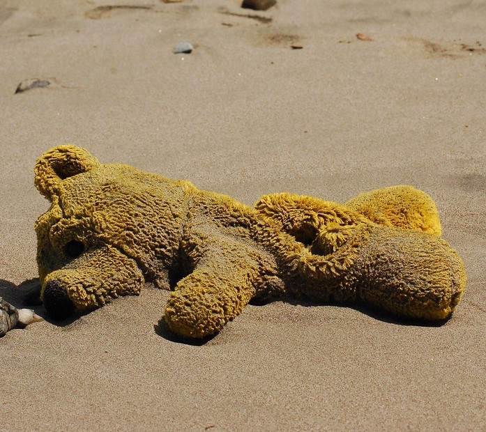Pooh bear stuffed animal on the beach