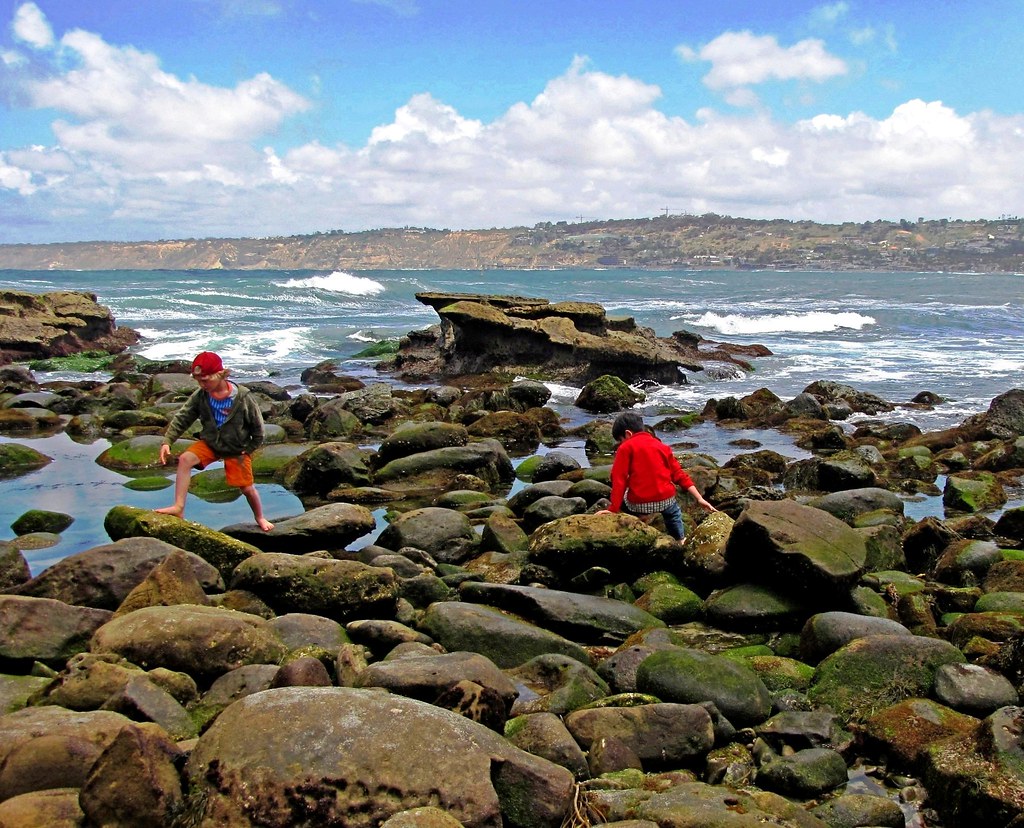 kids walking on rocks in the water.