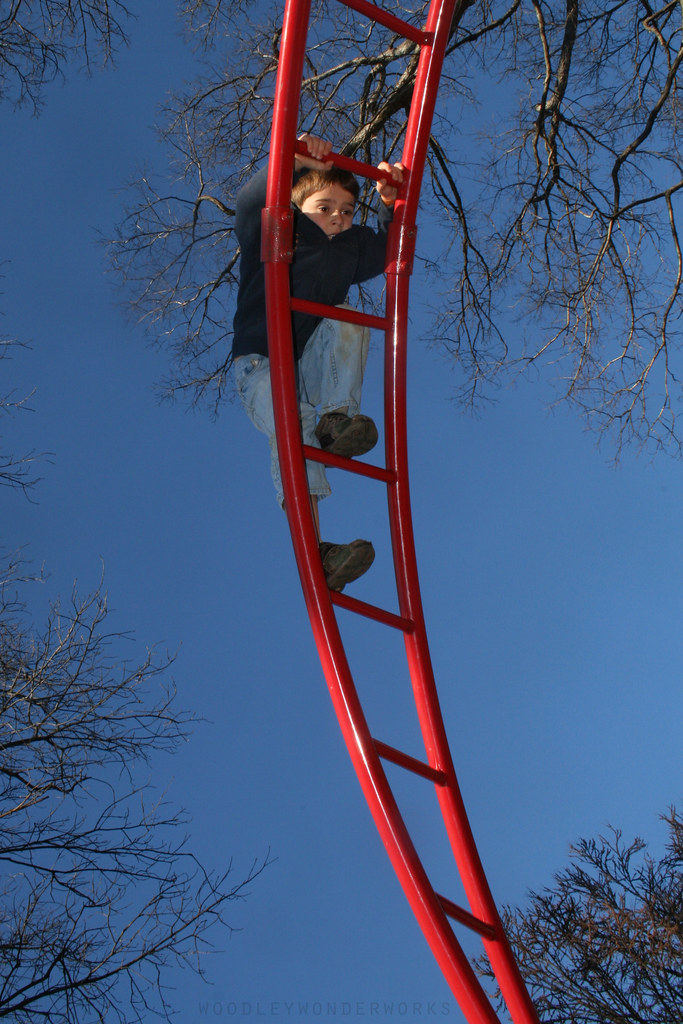 kid climbing playground equipment