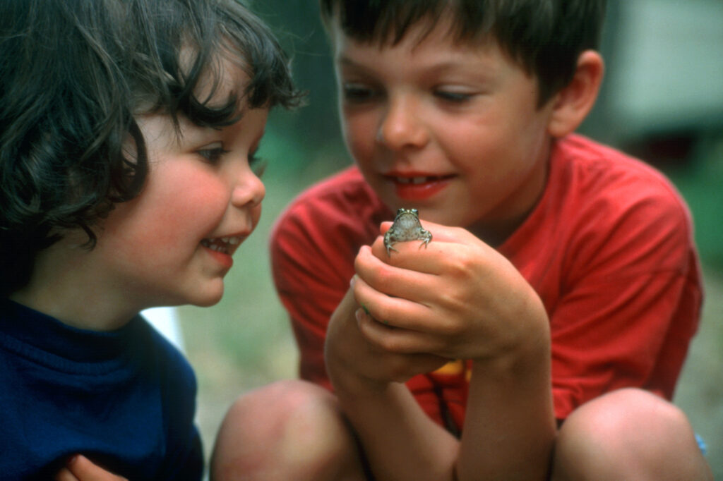 two kids holding a frog
